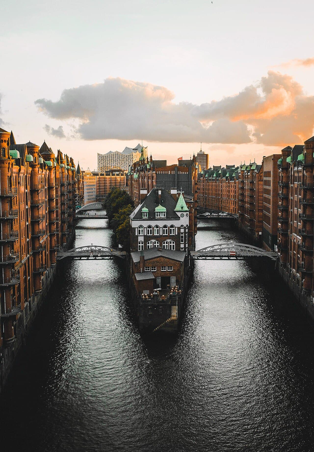 Das beleuchtete Wasserschloss in der Hamburger Speicherstadt bei Sonnenuntergang